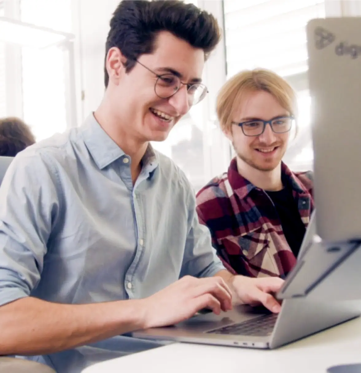 Digio employees collaborating on a computer.